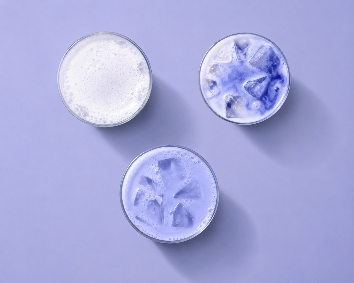 Three round containers with blue and white contents on a purple background
