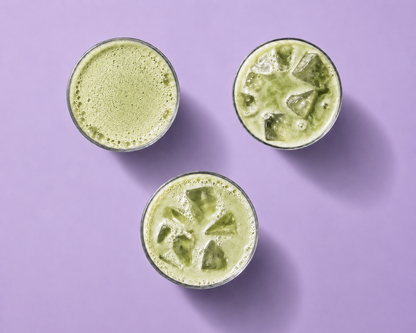 Three glasses of green smoothies on a purple background